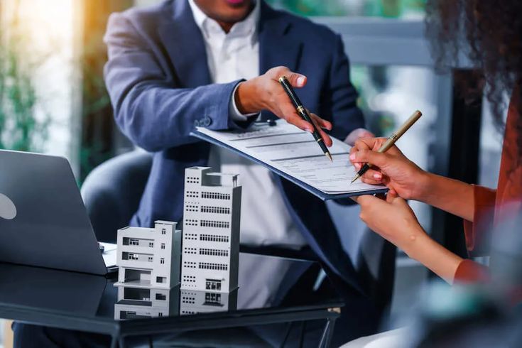 Real estate agent handing a contract to client for signature during a property agreement.